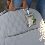 Gold poop bag pouch attached to the 3-in-1 dog travel bag via a sturdy metal ring. The pouch is compact and stylish, designed and crafted in Stockholm.